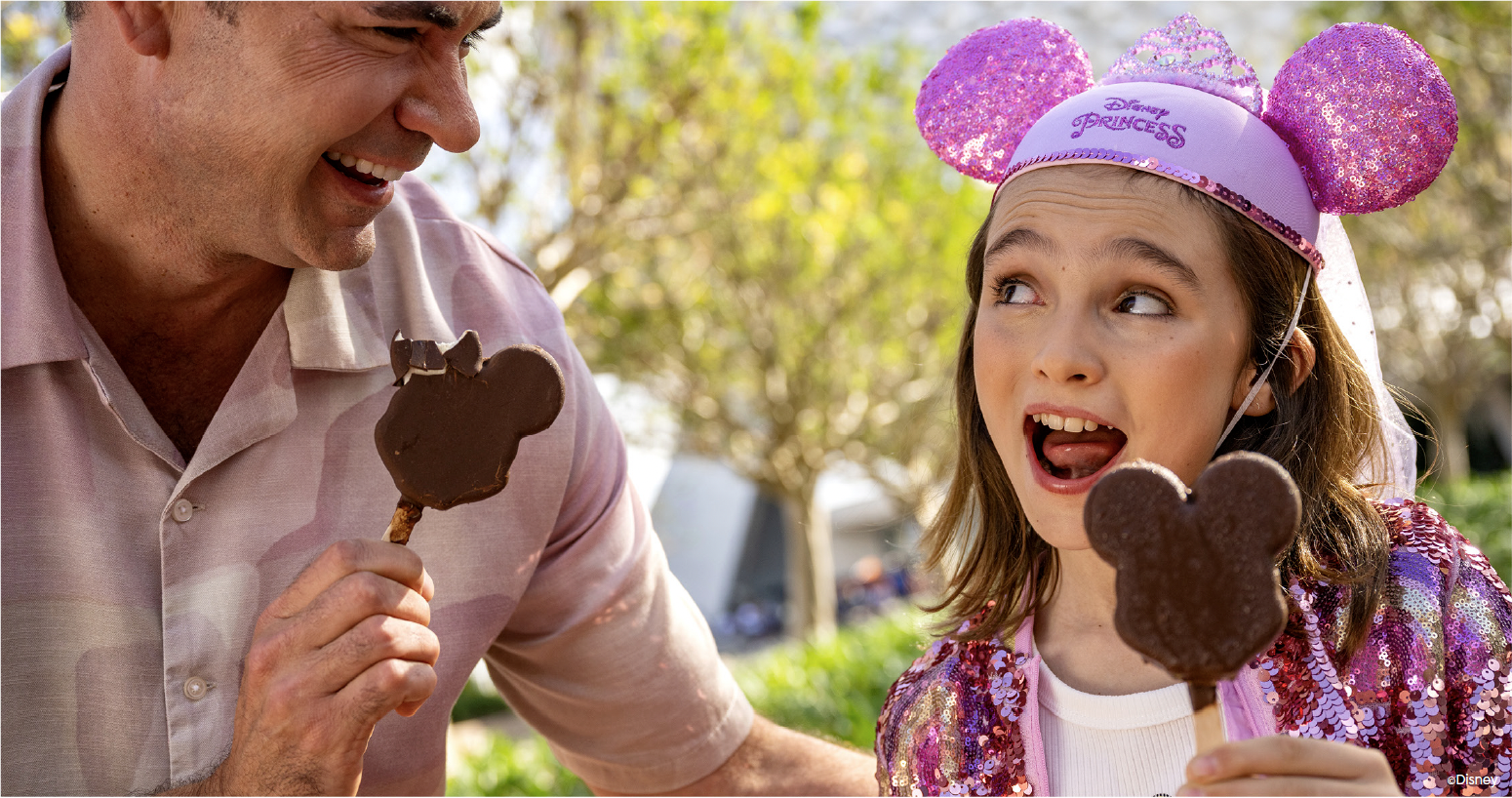 A Guest and child sharing Mickey Mouse ice cream bars at Walt Disney World